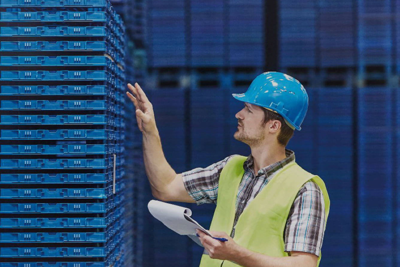 Man in a high visibility vest in a warehouse.